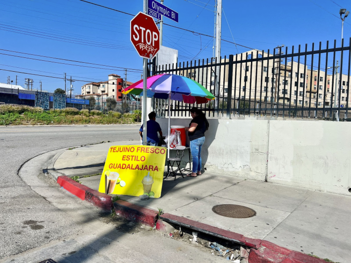 A tejuino stand with a rainbow umbrella.