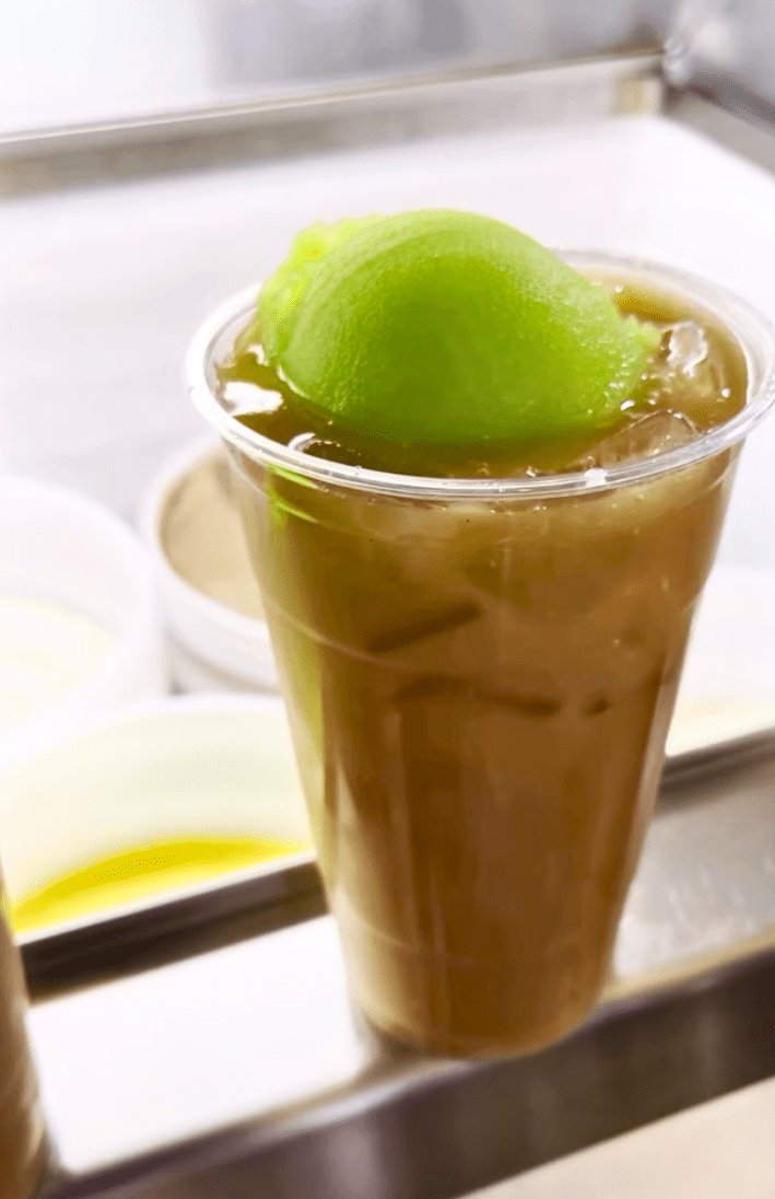 A cup of tejuino topped with nieve de garrafa de limon.