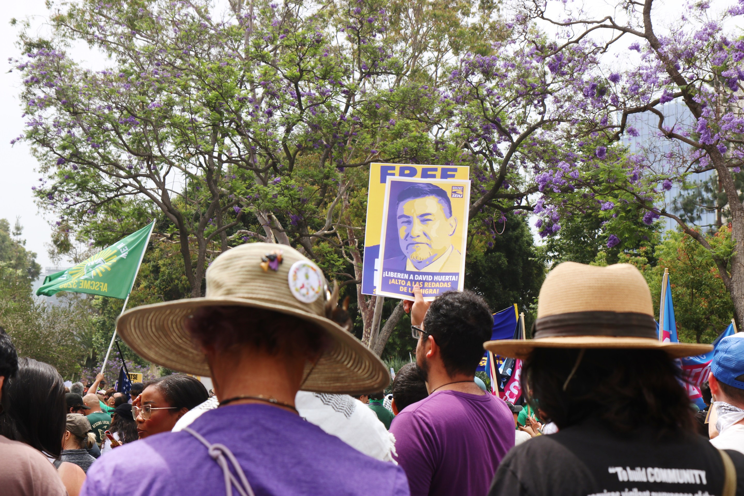 Protests signs being held up showing the face of union leader David Huerta